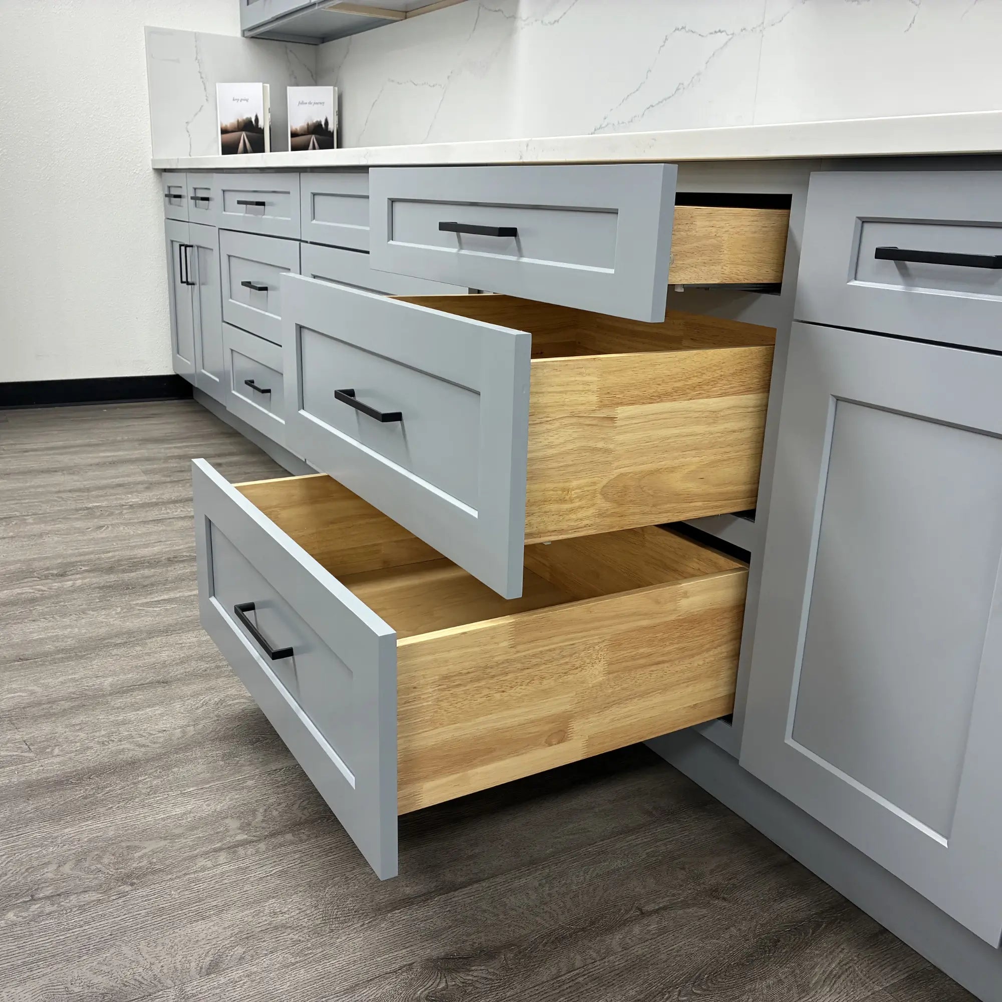 Gray shaker kitchen cabinets with soft-close wood drawers and black hardware displayed in the Las Vegas showroom kitchen design.